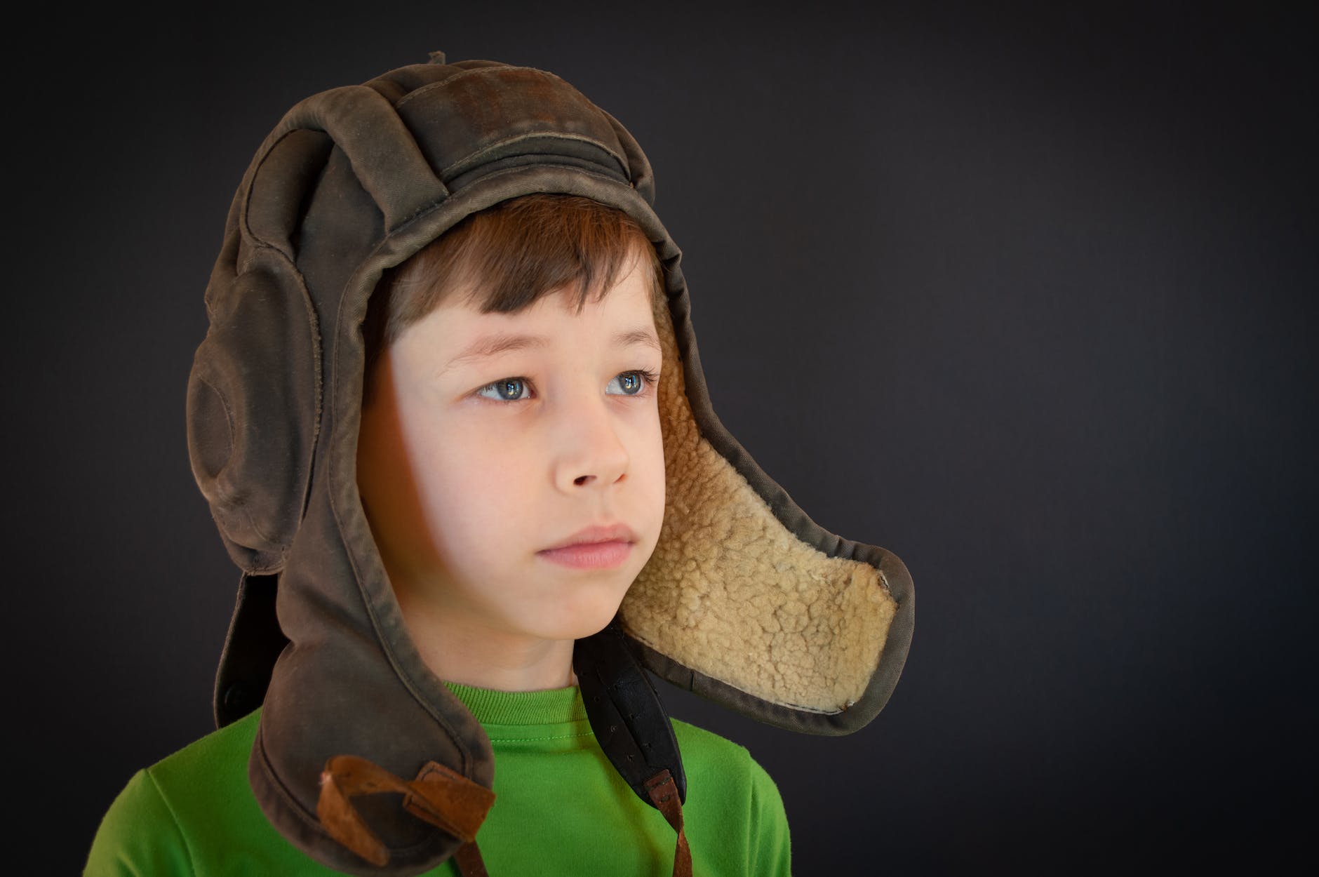 a boy wearing a vintage pilot hat