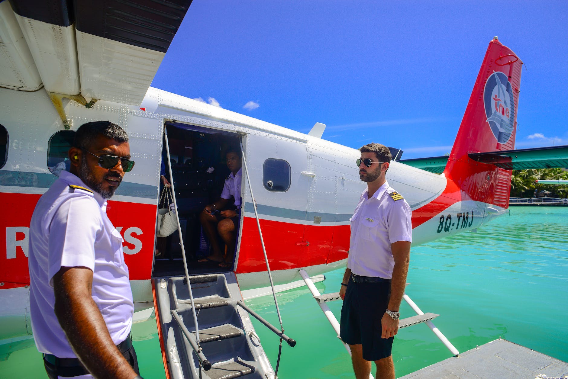 man standing beside of white and red airplane